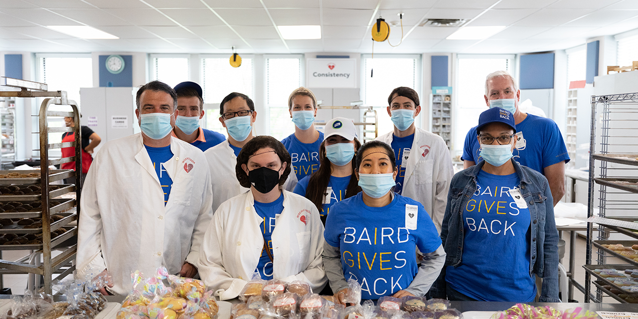 Baird Capital associates wearing Baird Cares t-shirts in the kitchen at a volunteer event